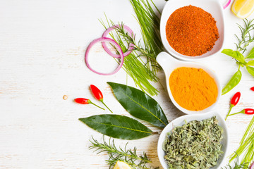 Dry colorful spices in bowls with fresh seasoning on white