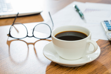 Cup of coffee and Office Supplies on wooden table
