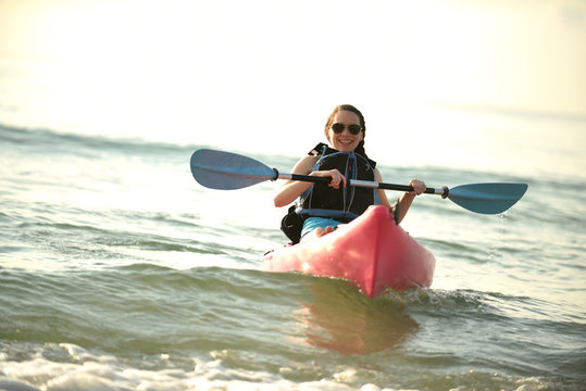 Pretty Young Woman Kayaking In Ocean