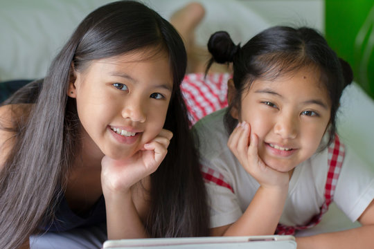 Close up of Asian child using tablet together
