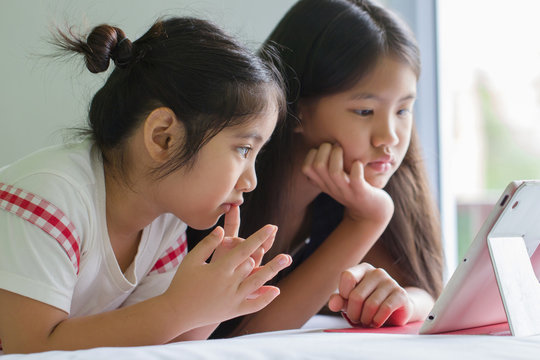 Close up of Asian child using tablet together