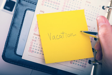 Vacation written on a memo at the office
