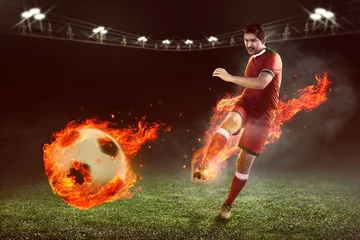 Rolgordijnen Asian football player kick fire ball © Leo Lintang