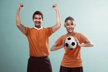 Foto op Plexiglas Happy couple football fan holding ball © Leo Lintang