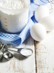 Baking soda, flour and eggs on wooden table.