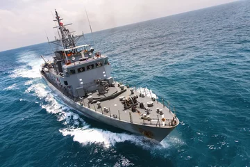 Militärische Marineschiffe in einer Meeresbucht mit Fischerboot, Blick aus der Luft © namning