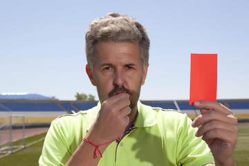 Angry football referee blowing a whistle