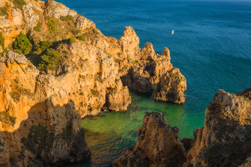 Fototapeta na wymiar Beautiful bay with rocks and turquoise water at the coast of Portimao. Algarve region. Portugal