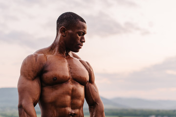 Portrait of handsome black african american athlete on the sunrise sky background