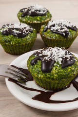 Fresh muffins with spinach, desiccated coconut and chocolate glaze, delicious healthy dessert