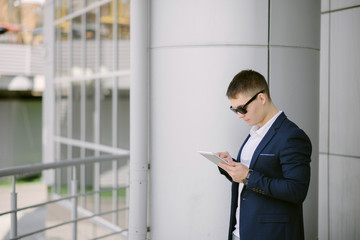 Portrait of a young businessman seeing on his tablet pc on the s