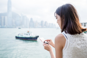 Fototapeta na wymiar Woman using cellphone at Hong Kong city