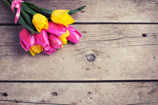 Bunch of  fresh yellow and pink spring tulips on vintage wooden