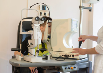 The doctor checks the child's eyes to device