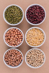 Assortment of beans and lentils in wooden spoon isolate on white