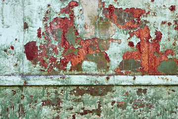 Close Up texture of Chipped peeling green paint over rust, covered with crumbling Paint
