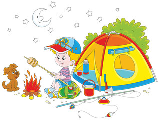 Little boy scout roasting bread on campfire near his camping tent