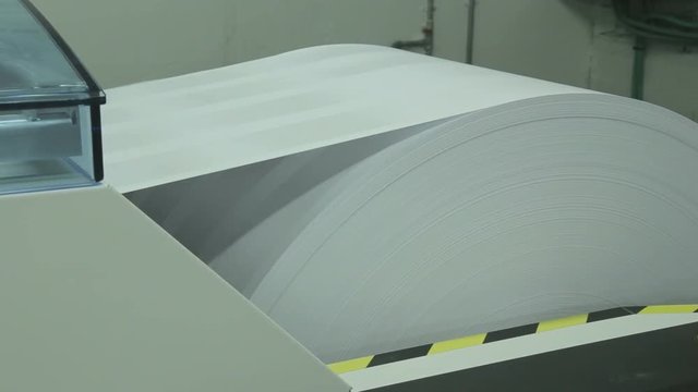  Side view on industrial paper roll feed into printer.