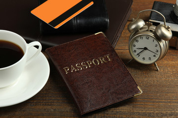 passport and credit card on laptop keyboard on a brown wooden background with Cup of coffee.Set of items for the trip