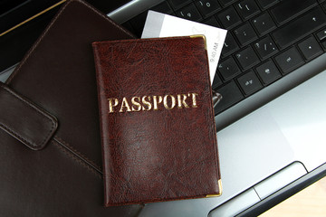 the passport with ticket and wallet on the laptop keyboard.Set of trip stuff