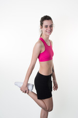 Athletic fitness woman stretching her legs on white background.
