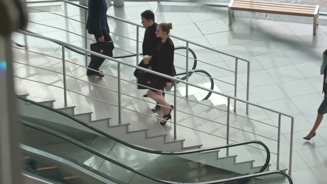 Business people walking up and down stairs in modern office building, slow motion shot on Sony NEX 700