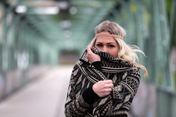 Beautiful blonde woman hiding her face behind her vest