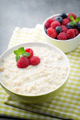Oatmeal porridge in bowl with berries raspberries and blackberri