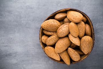 Group of almond nuts with leaves.Wooden background.