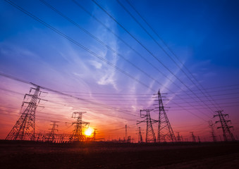 Fototapeta premium The silhouette of the evening electricity transmission pylon