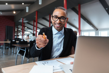 Businessman smiling and pointing at the working place