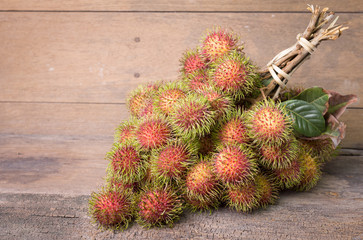 Fototapeta premium Fresh rambutan on wooden background