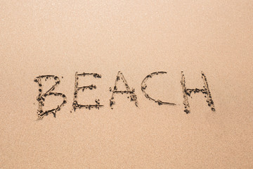 word Beach written on the sand