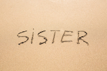 Sister word handwritten on a sand of beach