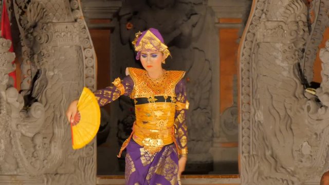 woman dances on stage performing balinese traditional barong dance in costume model release signed