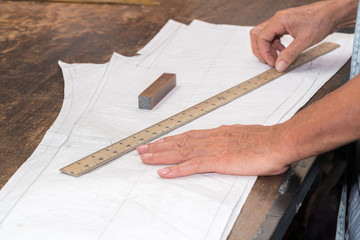 Tailor or clothing designer marking out a pattern for a handmade garment 
