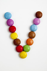 La lettera V formata da coloratissimi confetti di cioccolato.