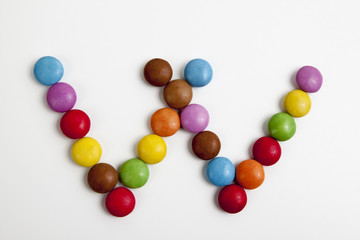 La lettera W formata da coloratissimi confetti di cioccolato.