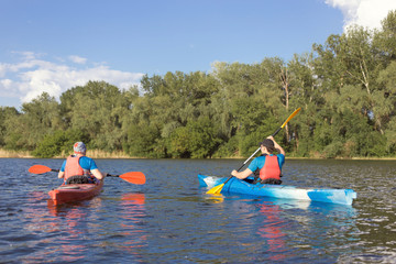 Man traveling on the river in a kayak in the summer.