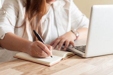 Businesswoman takes notes from a laptop in the office
