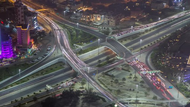 Skyline and traffic on crossroad night timelapse in Kuwait City downtown illuminated at dusk. Kuwait City, Middle East