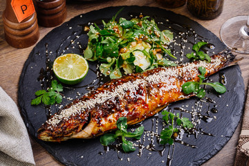 seabass grilled on a plate with vegetables and lemon  for the me
