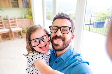 Father with his little daughter sticking tongue out