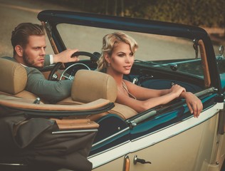 Wealthy couple in a classic convertible