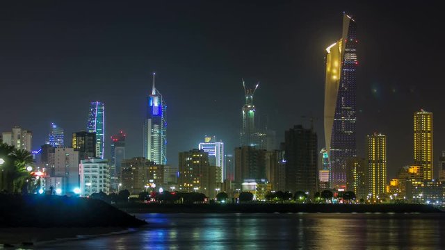 Skyline with Skyscrapers night timelapse in Kuwait City downtown illuminated at dusk. Kuwait City, Middle East