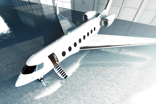 Photo of White Glossy Luxury Generic Design Private Jet parking in hangar airport. Concrete floor. Business Travel Picture. Horizontal, top angle view. Film Effect. 3D rendering.