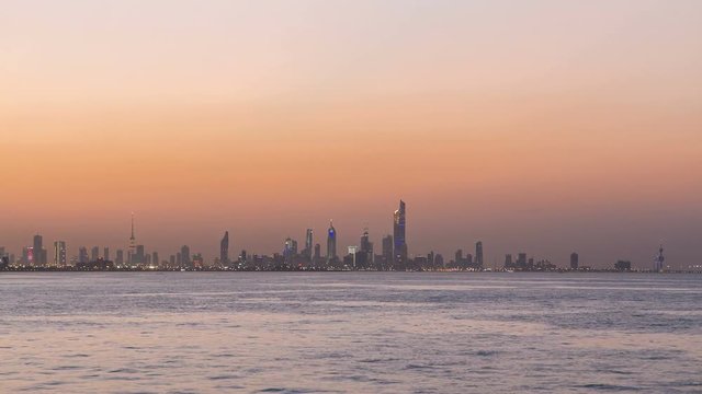 Skyline with Skyscrapers day to night timelapse in Kuwait City downtown illuminated at dusk. Kuwait City, Middle East