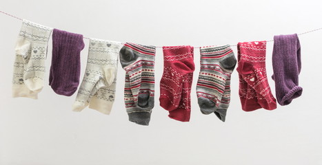 Various socks hanging on a wire