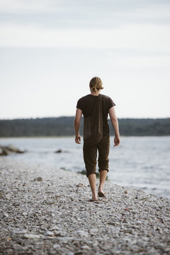 Young man walking on beach, Gotland, Sweden