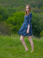 Beautiful girl standing in the grass on sunset